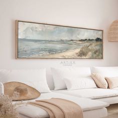 a painting hanging on the wall above a white couch