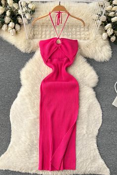 a pink dress on a hanger next to flowers and a white furnishing