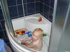 a baby sitting in a bathtub with toys