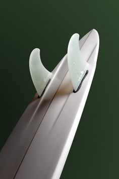 the surfboard is white and has two blades sticking out of it