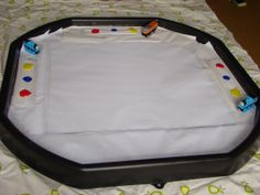 a black and white tray on top of a bed with polka dot sheets in it