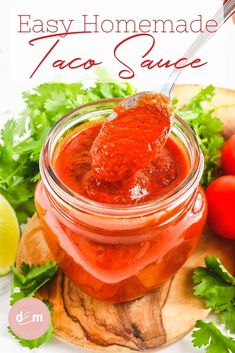 easy homemade taco sauce in a jar on a cutting board with tomatoes and cilantro