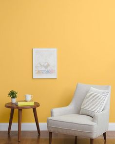 a white chair sitting next to a small table on top of a hard wood floor