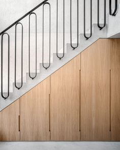 a person riding a skateboard down the side of a wooden stair case next to a hand rail