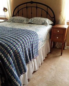 a bedroom with a bed, nightstand and window