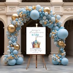 a baby shower sign surrounded by blue and gold balloons in front of a white arch