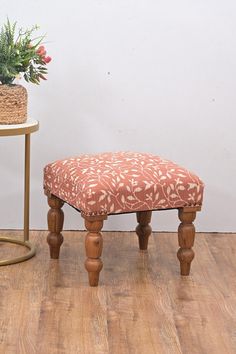 a small wooden bench sitting next to a potted plant