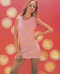 a woman in a pink crochet dress posing for a photo with her hands on her hips