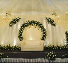 a decorated stage with white flowers and greenery