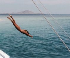 a man diving into the ocean from a boat