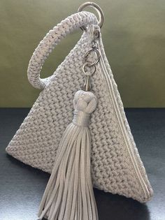 a crocheted purse with a tasseled handle and keychain hanging from it