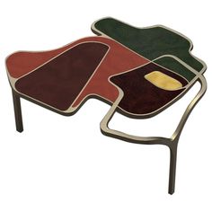 a coffee table with three different colored shapes on the top and one is shaped like a flower