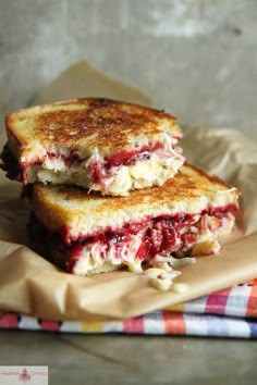 two grilled cheese sandwiches stacked on top of each other with cranberry sauce