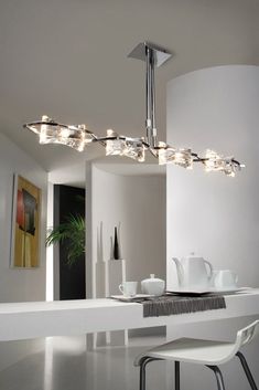 a modern chandelier hanging over a dining room table