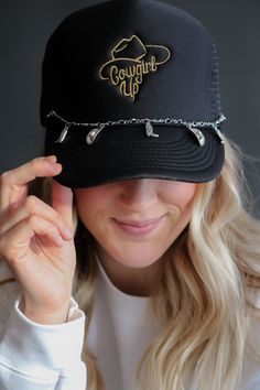 A black adjustable mesh back trucker cap with a rope hatband This cap has a "Cowgirl Up" gold graphic embroidered in the front. Does not come with silver hatband chain. Buy chain separate. Hat Charms, Adjustable Gold Trucker Hat, Gold Adjustable Trucker Hat, Hat Jewelry, Rancher Hat, Sweater Layering, Hat Band, Ball Cap, Performance Outfit