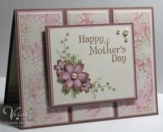 a mother's day card with pink flowers and pearls on the front, sitting on a table