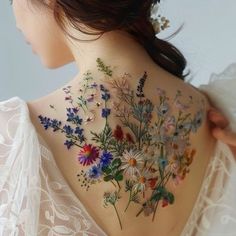 the back of a woman's neck with flowers on it