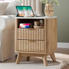 a wooden table with drawers and a laptop on it's stand next to a white couch