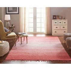 a living room scene with focus on the area rug and chair in the foreground