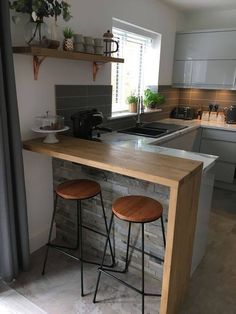 two stools are sitting at the bar in this small kitchen with an island counter