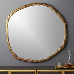 a round mirror sitting on top of a wooden dresser