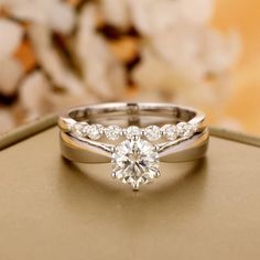 an engagement ring with two matching bands and a round brilliant cut diamond in the center