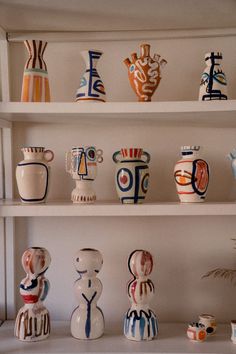 many different vases on shelves in a room