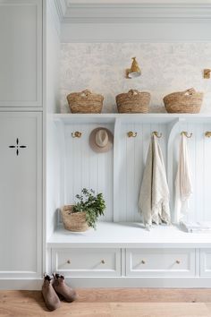 a white bench with baskets and hats on it