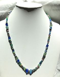 "24 inch blue crystal necklace. Austrian crystal and Czechoslovakian glass from our collection in shades of peridot, silver glass pearl and light sapphire. Many of the beads are rare and irreplaceable, originating from Czechoslovakia, Bavaria, Wattens, Kobe and Milano. Metal parts from our own tooling are antiqued bronze. \"Great Rushes\" is 24 inches long, handmade in the USA. Owen Glass Collection jewelry is ready for gift giving, with an organza bag and description card included. Please let u Single Strand Glass Spiritual Necklace, Single Strand Spiritual Glass Necklace, Spiritual Single Strand Glass Necklace, Blue Czech Glass Spiritual Necklace, Blue Spiritual Czech Glass Necklace, Spiritual Blue Czech Glass Necklace, Iridescent Round Glass Beads Jewelry, Iridescent Round Glass Bead Jewelry, Iridescent Glass Jewelry With Round Beads