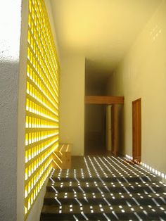 an empty hallway with sunlight shining through the blinds