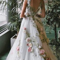 a woman wearing a wedding dress with flowers on it