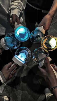 several people holding their hands together in the shape of a circle with glowing lights on them