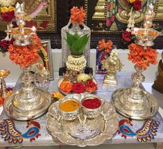 a table topped with silver plates covered in flowers and saucers filled with different types of condiments