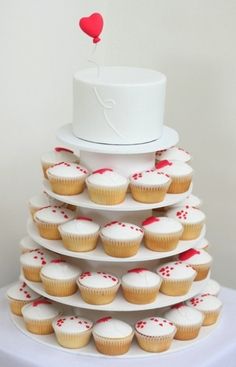 cupcakes are stacked on top of each other in front of a white cake