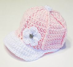 a pink and white crocheted hat with a flower