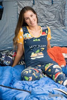 a woman sitting on top of a blue bed