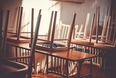 there are many chairs lined up on the table and one has a tray with shoes in it