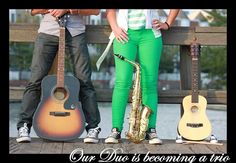 two people standing next to each other with guitars and saxophones in front of them