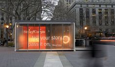 a bus stop sitting on the side of a street next to tall buildings with windows