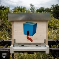 a beehive with a red worm in it's mouth and a blue box on the back