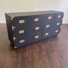 a black dresser with gold handles and drawers