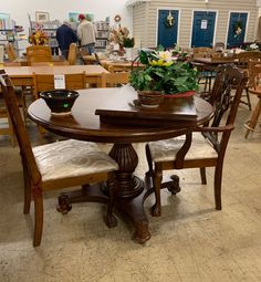 a table and chairs in a room filled with tables, chairs and bookshelves