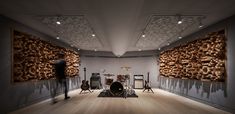 an empty room with guitars, drums and other musical instruments on the wall in front of it