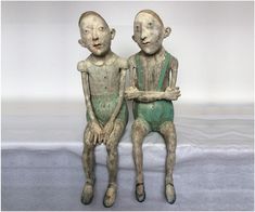 two clay figures sitting next to each other