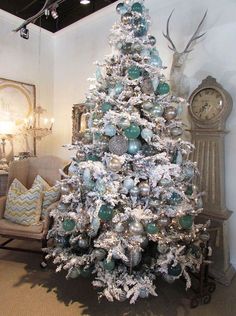 a white christmas tree with blue and silver ornaments