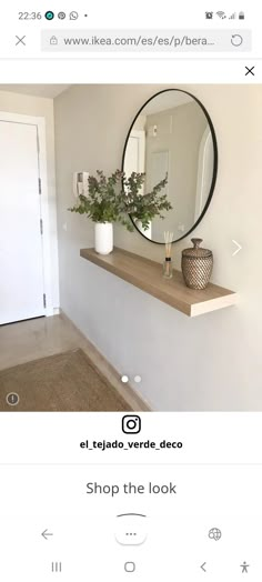 a mirror on the wall above a shelf with flowers in vases next to it