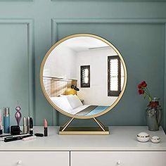 a mirror sitting on top of a white dresser