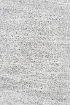 an abstract gray and white background with small speckles on the surface, including lines