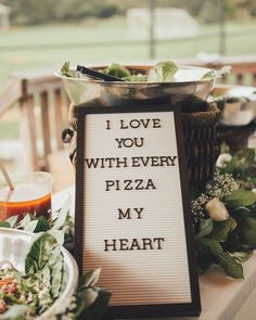 a sign that says i love you with every pizza my heart on it next to some food