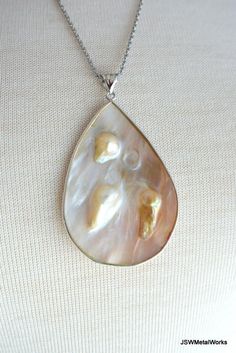 This sterling silver blister shell pendant necklace is so stunning in its simplicity. Perfect for someone who loves an attention-getting piece that truly makes a statement. A teardrop blister shell encased in sterling silver hangs off a sturdy 24 inch stainless steel cable chain. The pendant measures ~ 2.5 inches in height (including the bail) and is 1.5 inches wide. There are two versions currently available. Select your preferred pendant from the pull down variation menu. Convo me for a differ Teardrop High Luster Necklace As A Gift, Teardrop High Luster Necklace Gift, Teardrop Pendant Jewelry With High Luster For Gifts, Silver Pear Drop Necklace For Anniversary, Silver Pear-shaped Drop Necklace For Anniversary, Perfume Making, Stainless Steel Cable, Necklace Statement, Chain Jewelry